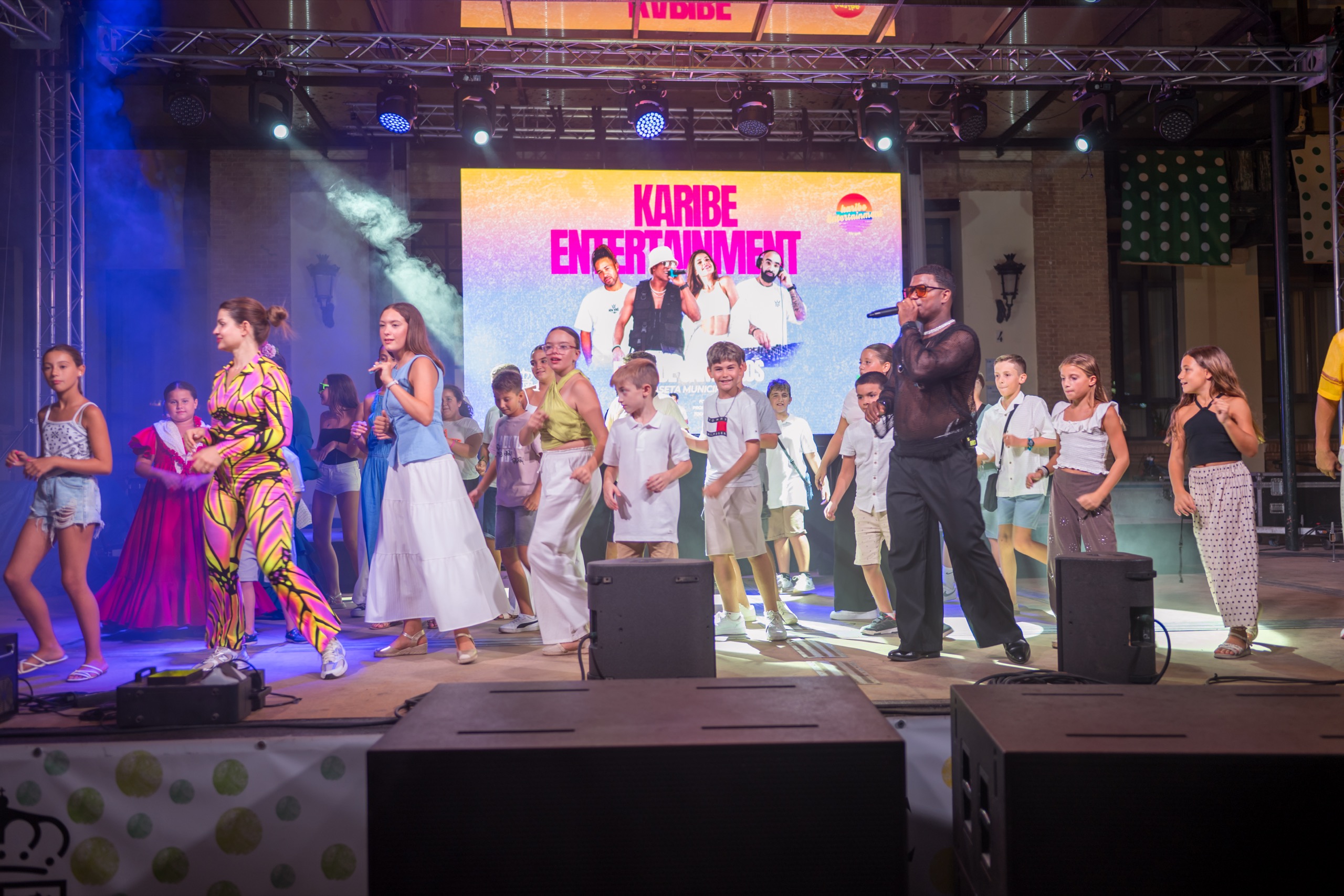 Niños y el equipo de Wonderly comparten la alegría de bailar juntos en el escenario